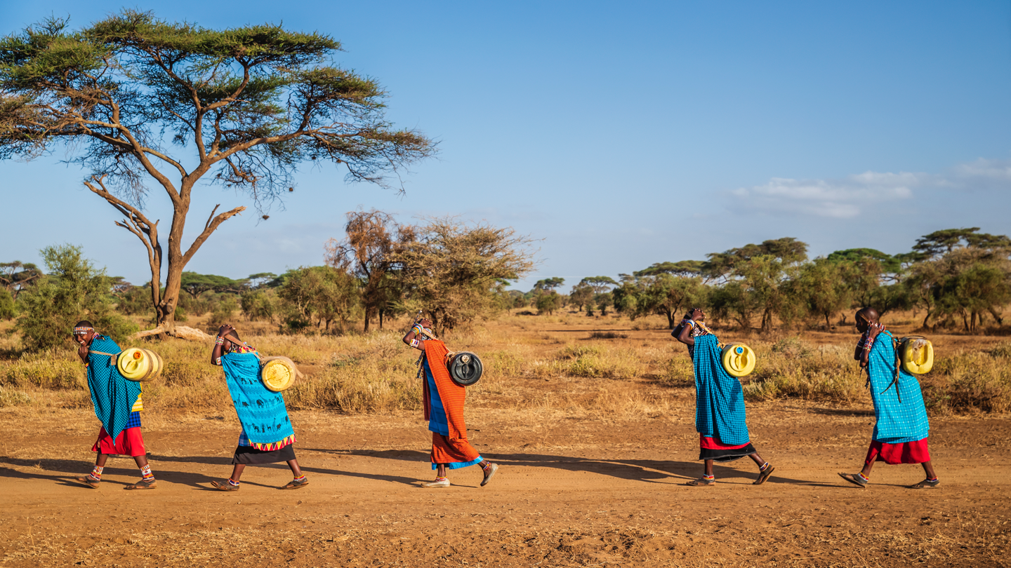 Women walking with jugs of water on their back